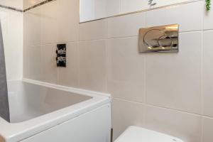 a white bathroom with a toilet and a bath tub at 3 Bed in Tenby oc-93359 in Redberth +16 photos