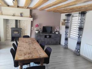 a dining room with a wooden table and a fireplace at La maison du petit peintre in Villaines-sous-Lucé