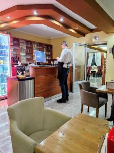 a man standing at the counter of a restaurant at Apartman Quattro 2 in Međugorje +15 photos