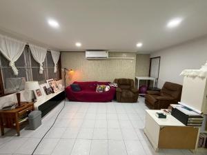 a living room with a red couch and chairs at Southeast Asia Activist House in Bangkok