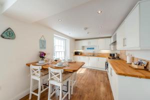 a kitchen with a wooden table and white cabinets at 2 Bed in Appledore oc-loblof in Appledore