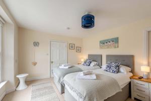 two twin beds in a room with white walls at 2 Bed in Appledore oc-loblof in Appledore