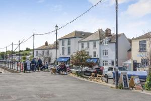 a group of people sitting on benches on a street at 2 Bed in Appledore oc-loblof in Appledore