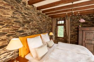a bedroom with a bed and a stone wall at Burg Coraidelstein in Klotten