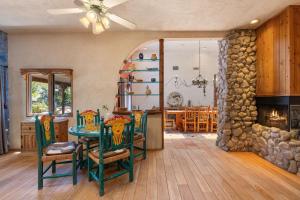 a living room with a table and a stone fireplace at The Bubbling Wells Oasis, 3 Homes on 107 Acres in Desert Hot Springs