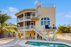 a house with a swimming pool in front of it at CJ314FLR The Mermaid Manor in Cudjoe Key