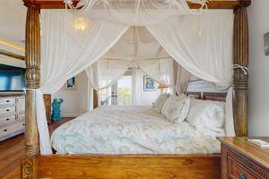 a bedroom with a canopy bed with a window at CJ314FLR The Mermaid Manor in Cudjoe Key +20 photos