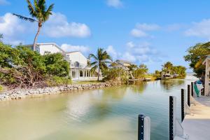 a river with houses and palm trees on the side at CJ314FLR The Mermaid Manor in Cudjoe Key