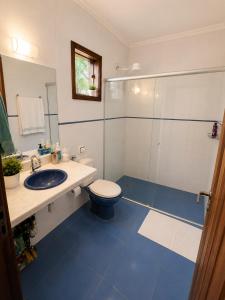 a bathroom with a toilet and a sink and a shower at Pousada Serra do Encanto in Delfinópolis