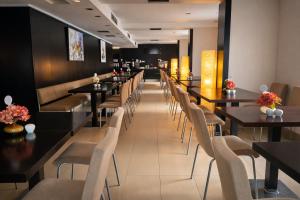 a long row of tables and chairs in a restaurant at Hotel CH Bucharest in Bucharest
