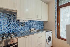 a kitchen with a sink and a washing machine at Serenity Troia, By Home Match in Troia