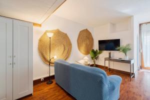 a living room with a blue chair and a lamp at Serenity Troia, By Home Match in Troia +18 photos