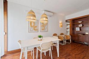 a dining room with a white table and chairs at Serenity Troia, By Home Match in Troia