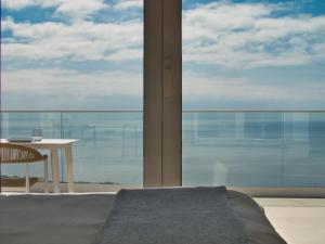 a room with a table and a large glass window at Casa Conchita in Angra do Heroísmo