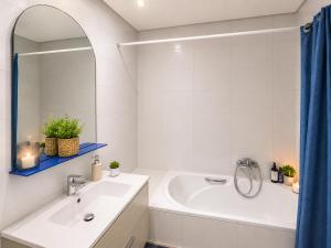 a white bathroom with a tub and a sink at Cozy Stay appartement in Sukrah