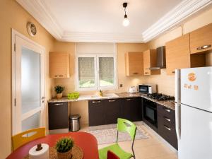 a kitchen with brown cabinets and a white refrigerator at Cozy Stay appartement in Sukrah