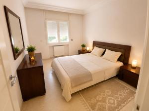 a bedroom with a large bed and two night stands at Cozy Stay appartement in Sukrah