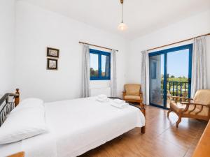 a white bedroom with two beds and a window at Villa Rotiana in Polis Chrysochous +14 photos