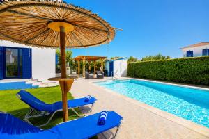 a blue chair and an umbrella next to a swimming pool at Villa Rotiana in Polis Chrysochous