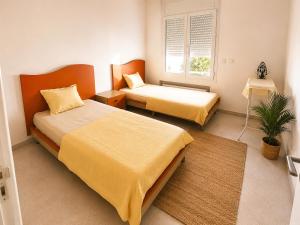 a bedroom with two beds and a window at Cozy Stay appartement in Sukrah
