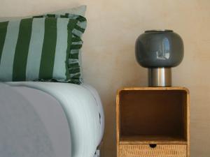 a side table with a lamp next to a bed at Casa Conchita in Angra do Heroísmo