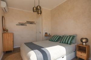 a bedroom with a bed with green and gray pillows at Casa Conchita in Angra do Heroísmo