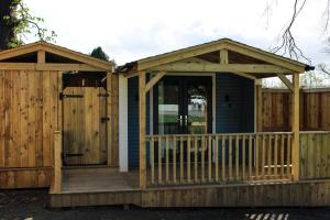 a wooden house with a porch and a gate at The Bannville Hotel in Banbridge