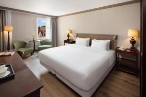 ein großes weißes Bett in einem Hotelzimmer in der Unterkunft NH Brugge in Brügge