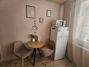 a small kitchen with a small table and a refrigerator at Апартаменти Aura Bliss in Zhytomyr