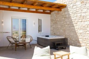 a living room with a stone wall and a fireplace at Sunshine Medousa Suite in Glifades +36 photos
