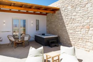 a patio with a hot tub and a table at Sunshine Medousa Suite in Glifades