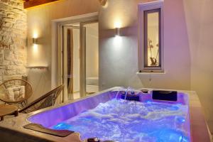 a large purple tub in a room with a table at Sunshine Medousa Suite in Glifades