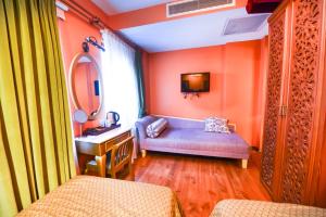 baño con paredes de color naranja, tocador y lavabo en Merial Hotel Sultanahmet en Estambul
