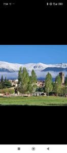 a view of a field with trees and snow covered mountains at El Nidito del valle del Tietar in La Iglesuela +14 photos