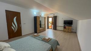 a bedroom with a bed and a television in it at Casa Maia Corbu in Corbu