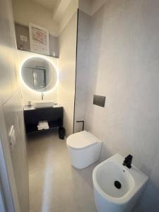a white bathroom with a toilet and a sink at Marilux oasi di relax in Marina di Carrara