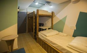 Cette chambre comprend 2 lits superposés et une table. dans l'établissement Pod N Beyond Smart Hotel, à Jamshedpur
