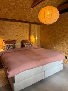 a bedroom with a large bed in a stone wall at Tinkerbell in Oosterbeek
