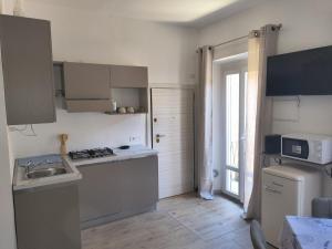 a small kitchen with a sink and a microwave at Il Flat Arona Centro, Le Dimore del Corso in Arona
