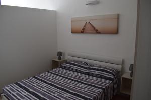 a bedroom with a bed with a striped blanket at Il Flat Arona Centro, Le Dimore del Corso in Arona