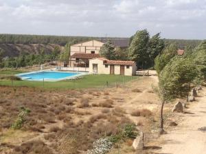 a house with a swimming pool in a field at Quinta del Quinoto in Pajares de Adaja