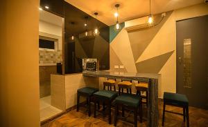 a kitchen with a bar with stools at Pod N Beyond Smart Hotel in Jamshedpur