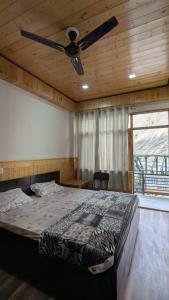 a bedroom with a large bed with a ceiling fan at Kunzang Homestay in Shalkār