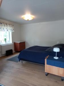 a bedroom with a blue bed and a window at Easystar guest house in Ingarö