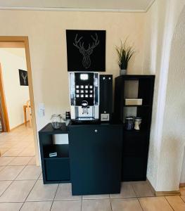 a kitchen with a black counter with a microwave at Pension Platzhirsch Vogelsberg in Mücke