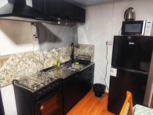 a kitchen with a black stove and a refrigerator at Serena in Maldonado