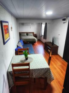 a living room with a table and a bed at Serena in Maldonado +4 photos