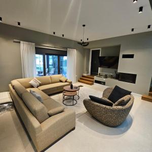 a living room with two couches and two chairs at Evia Palm Beach Villa in Politika
