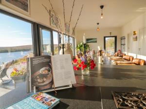 a room with a table with books and flowers at Hanowen House in Dungloe