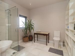 a bathroom with a shower and a sink and a toilet at Hanowen House in Dungloe +49 photos